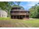 A shot of a two story home with deck overlooking the spacious yard and a wooded area in the background at 300 Twin Tendrils Sw, Atlanta, GA 30331