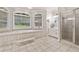 Bright bathroom boasts a soaking tub, tiled floor, large windows, and separate shower at 507 Wintergreen Way, Canton, GA 30115