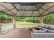 Beautiful outdoor deck space with a covered gazebo, comfortable seating, and a tranquil wooded view at 507 Wintergreen Way, Canton, GA 30115