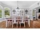 Traditional dining room features wood floors, large windows, decorative lighting, and a white wood dining table set at 507 Wintergreen Way, Canton, GA 30115