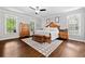Spacious main bedroom with hardwood floors, sitting area, ceiling fan, and natural light at 507 Wintergreen Way, Canton, GA 30115