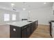 A kitchen with modern island features stainless sink, dark cabinets, and pendant lights at 913 Agate Ln, Lawrenceville, GA 30043