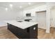 Well-lit kitchen with stainless steel microwave, island with sink, and white cabinets at 913 Agate Ln, Lawrenceville, GA 30043