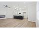 Spacious living area featuring light wood flooring, a modern fireplace, and a kitchen island at 913 Agate Ln, Lawrenceville, GA 30043