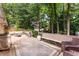Inviting wooden deck featuring string lights, comfortable seating, and a view of the wooded backyard, perfect for outdoor relaxation at 999 Seaboard Nw Ave, Atlanta, GA 30318