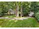 Spacious backyard featuring a charming shed, verdant lawn, and a stone pathway surrounded by mature trees and greenery at 999 Seaboard Nw Ave, Atlanta, GA 30318