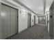 Hallway with gray carpet and neutral walls with recessed trim and four elevator doors with lighted sconces at 1280 W Peachtree Street Nw # 808, Atlanta, GA 30309