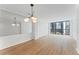 Bright living room with hardwood floors, a contemporary chandelier, and large window with city views at 1280 W Peachtree Street Nw # 808, Atlanta, GA 30309