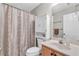 Well-lit bathroom features vanity sink, toilet, and shower with curtain at 1530 Brisbane Dr, Dacula, GA 30019