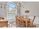 Elegant dining room with a large window, classic chandelier, and wood furniture on a patterned rug at 1530 Brisbane Dr, Dacula, GA 30019