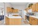 Functional kitchen design with light wood cabinets, white countertops, and modern appliances with view into living room at 1530 Brisbane Dr, Dacula, GA 30019
