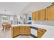Well-lit kitchen featuring white countertops, wooden cabinets, and views into the adjacent breakfast area at 1530 Brisbane Dr, Dacula, GA 30019