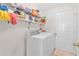 Functional laundry room equipped with washer, dryer, and shelving for storage at 1530 Brisbane Dr, Dacula, GA 30019