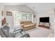 Bright and airy living room with a vaulted ceiling, large windows, a cozy sofa and TV at 1530 Brisbane Dr, Dacula, GA 30019