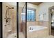 Bright bathroom featuring a glass-door shower, separate tub, and tiled walls at 2822 Prado Ln, Marietta, GA 30066