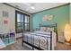 Bright bedroom with a metal bed frame, turquoise accent wall, and shuttered windows at 2822 Prado Ln, Marietta, GA 30066