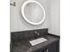 A modern bathroom featuring granite countertops, vanity and stylish round mirror at , Atlanta, GA 30315