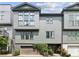 Contemporary townhome with gray siding, large windows, and a two-car garage with verdant foliage at , Atlanta, GA 30315