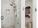 Modern tiled shower with rainfall showerhead and storage nook, complemented by stylish floating shelves in the bathroom at , Atlanta, GA 30315