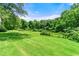 Expansive backyard featuring a lush lawn and mature trees, offering privacy and a serene outdoor space at 1003 Cannongate Sw Xing, Marietta, GA 30064