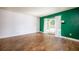 Open living space features hardwood floors, white walls, and a bright green accent wall at 136 Peachtree Memorial Nw Dr # Pa4, Atlanta, GA 30309
