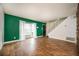 Living room with hardwood floors, a bright green accent wall, and a staircase at 136 Peachtree Memorial Nw Dr # Pa4, Atlanta, GA 30309