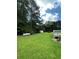 Spacious backyard featuring manicured lawn, mature trees, with a deck, and a storage shed at 1631 Billy Bullock Rd, Dallas, GA 30157