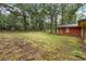 View of the backyard and exterior of the house with mature trees at 223 Dogwood Ln, Lawrenceville, GA 30046