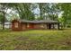 Exterior view of home surrounded by greenery, showcasing the backyard and siding at 223 Dogwood Ln, Lawrenceville, GA 30046