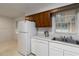 Bright kitchen featuring white appliances, double sinks, and ample counter space for food preparation and storage at 223 Dogwood Ln, Lawrenceville, GA 30046