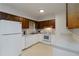 Well-lit kitchen with white appliances, countertops, and wooden cabinets, creating a clean and functional cooking space at 223 Dogwood Ln, Lawrenceville, GA 30046
