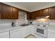 Functional kitchen featuring white appliances, double sinks, and wooden cabinets for an efficient and organized cooking experience at 223 Dogwood Ln, Lawrenceville, GA 30046