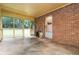 Enclosed back porch featuring brick wall, screens, and concrete floor overlooking the backyard at 223 Dogwood Ln, Lawrenceville, GA 30046