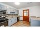 Galley kitchen featuring stainless steel appliances, light gray cabinetry, granite countertops and mosaic backsplash at 2923 Bicentennial Dr, Stone Mountain, GA 30087