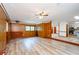 Spacious living room featuring paneled walls, wood flooring and a ceiling fan at 2923 Bicentennial Dr, Stone Mountain, GA 30087