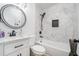 Beautiful bathroom featuring a sleek vanity, a round mirror, and a tiled bathtub with a shower at 4020 Ester Sw Dr, Atlanta, GA 30331