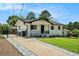 Home featuring a concrete driveway with stone trim, manicured lawn, and a wrought-iron fence at 4020 Ester Sw Dr, Atlanta, GA 30331