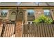 A brick townhouse displaying covered entryways, a fenced patio, and trimmed landscaping at 6980 Roswell Rd # P6, Atlanta, GA 30328