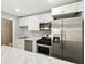 Well-lit kitchen features stainless steel appliances, white cabinets and marbled countertop at 6980 Roswell Rd # P6, Atlanta, GA 30328