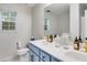 Bright bathroom boasts double sinks, blue vanity, gold fixtures, and marble-look floors at 102 Natalie Ct, Dallas, GA 30157