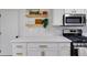 Bright kitchen features white cabinets, gold hardware, quartz countertops, and subway tile backsplash at 102 Natalie Ct, Dallas, GA 30157