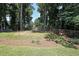 Large, grassy backyard with mature trees, wooden fence, and shed, perfect for outdoor activities at 1313 Old Countryside Cir, Stone Mountain, GA 30083