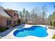 Aerial view showcasing a luxurious brick home, pool, and meticulously landscaped backyard at 297 Collegiate Dr, Powder Springs, GA 30127