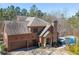 Beautiful brick home featuring a two-car garage, stone accents, chimney, and a sparkling blue pool at 297 Collegiate Dr, Powder Springs, GA 30127