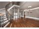 Elegant foyer with a curved staircase, hardwood floors, stone column and crown molding at 297 Collegiate Dr, Powder Springs, GA 30127