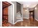 Open foyer with wooden staircase, wood-look ceramic flooring, and decorative pendant light at 297 Collegiate Dr, Powder Springs, GA 30127
