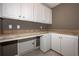 Well-equipped laundry room with ample counter space and cabinetry for efficient organization at 297 Collegiate Dr, Powder Springs, GA 30127