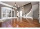 Spacious living room with gleaming hardwood floors, large windows, and a grand staircase and stone fireplace at 297 Collegiate Dr, Powder Springs, GA 30127