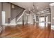 Open-concept living room with hardwood floors, grand staircase, stone column, coffered ceilings, and a fireplace at 297 Collegiate Dr, Powder Springs, GA 30127
