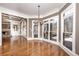 Open living area with hardwood floors, large windows, stone fireplace, and elegant lighting fixtures at 297 Collegiate Dr, Powder Springs, GA 30127